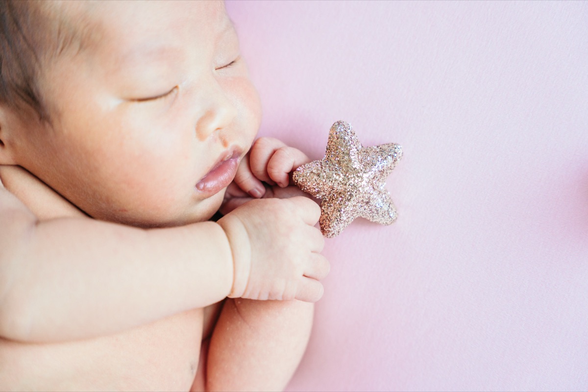 星のモチーフに包まれて眠るニューボーンフォトの赤ちゃん