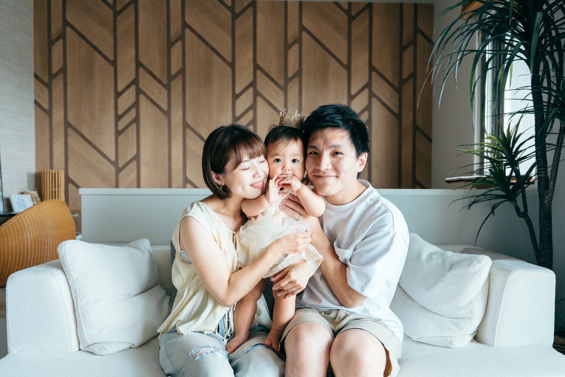 リビングで赤ちゃんを抱く親子の家族写真