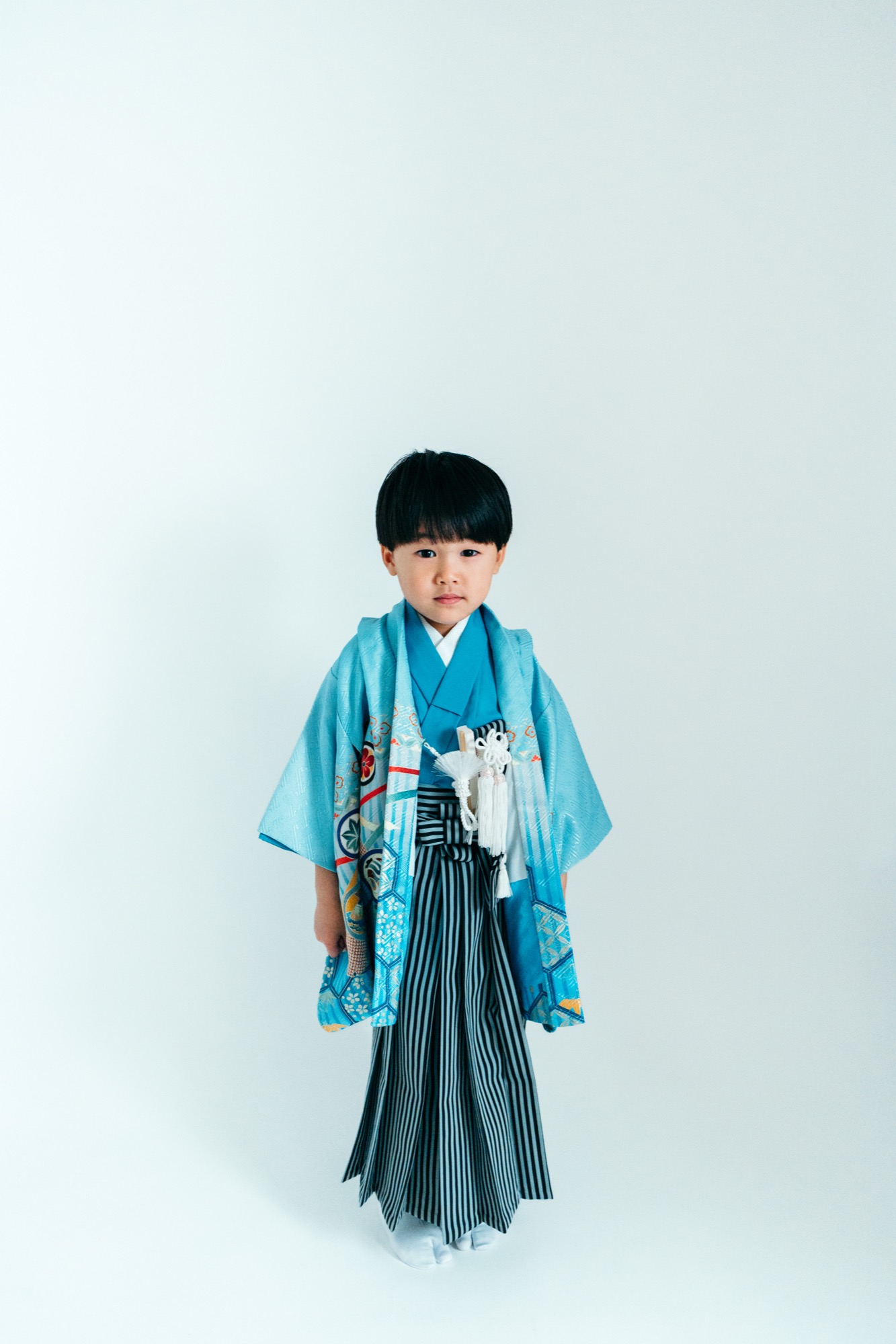 水色の羽織と縞袴の七五三・5歳男の子の全身スタジオ写真