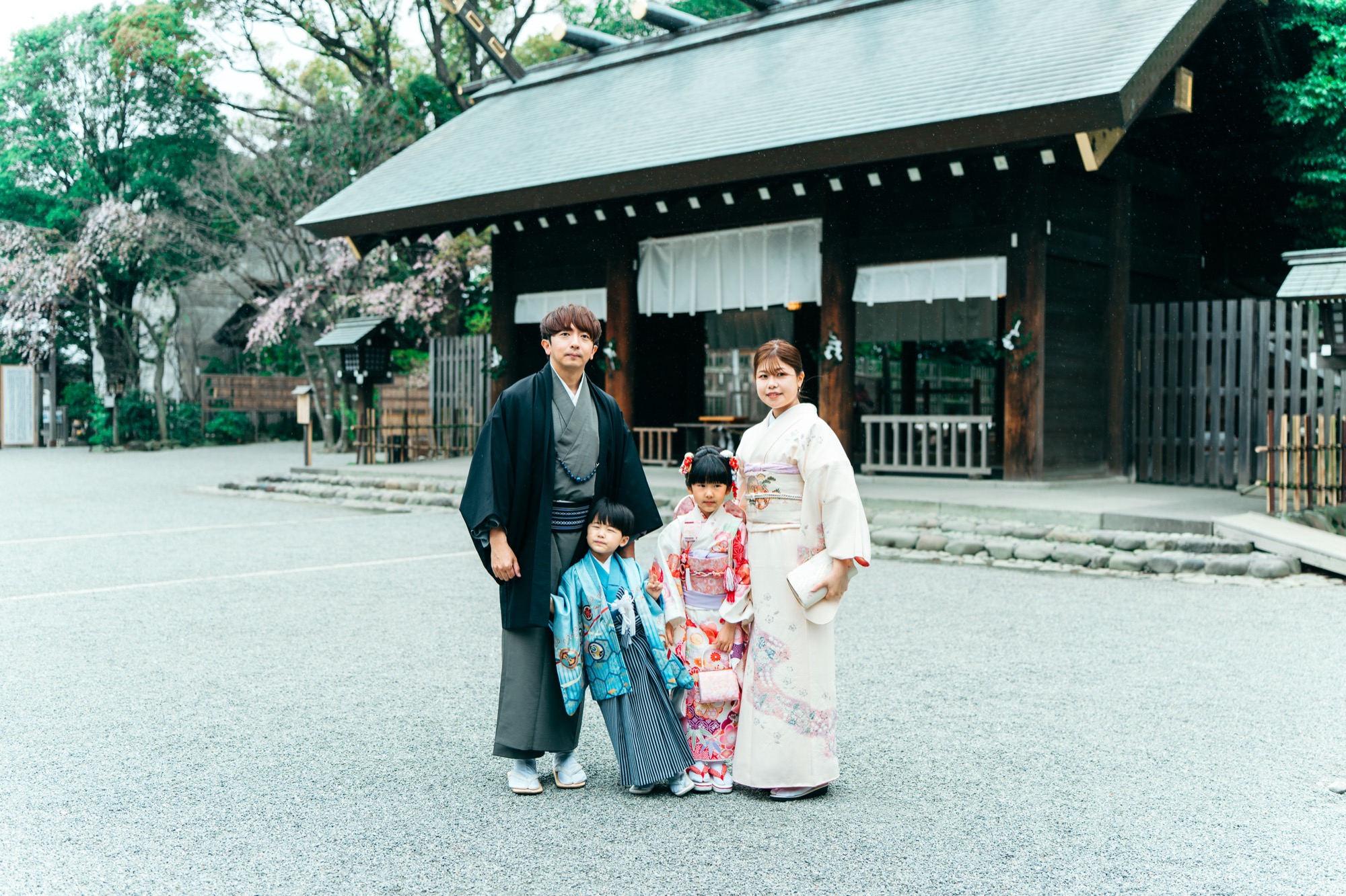 伊勢山皇大神宮の社殿前に並ぶ七五三の家族写真（パパ・ママと7歳女の子・5歳男の子）