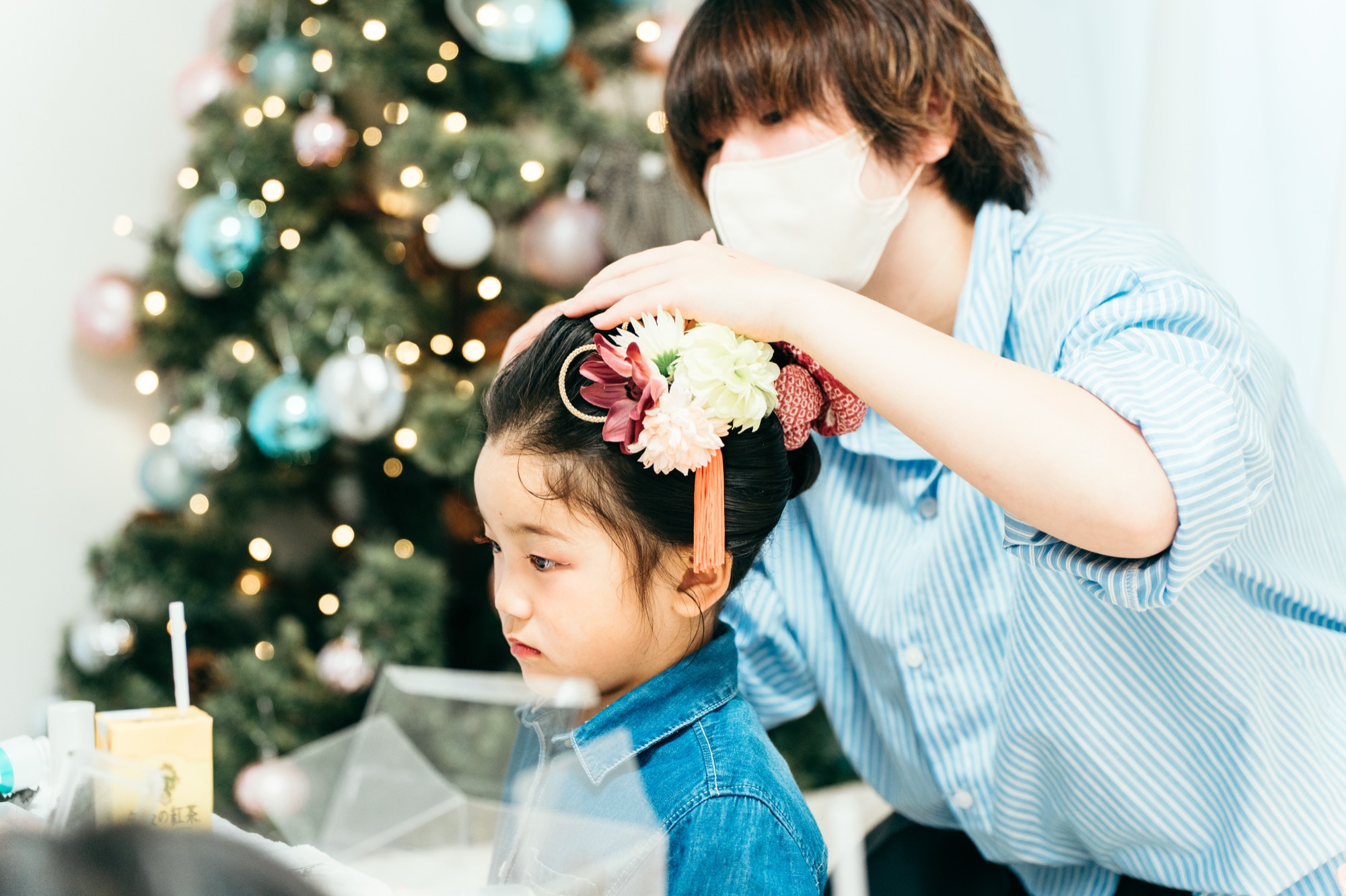 横浜のプライベートスタジオでのお支度。7歳の女の子の髪に花の髪飾りをつける七五三のヘアメイクの様子