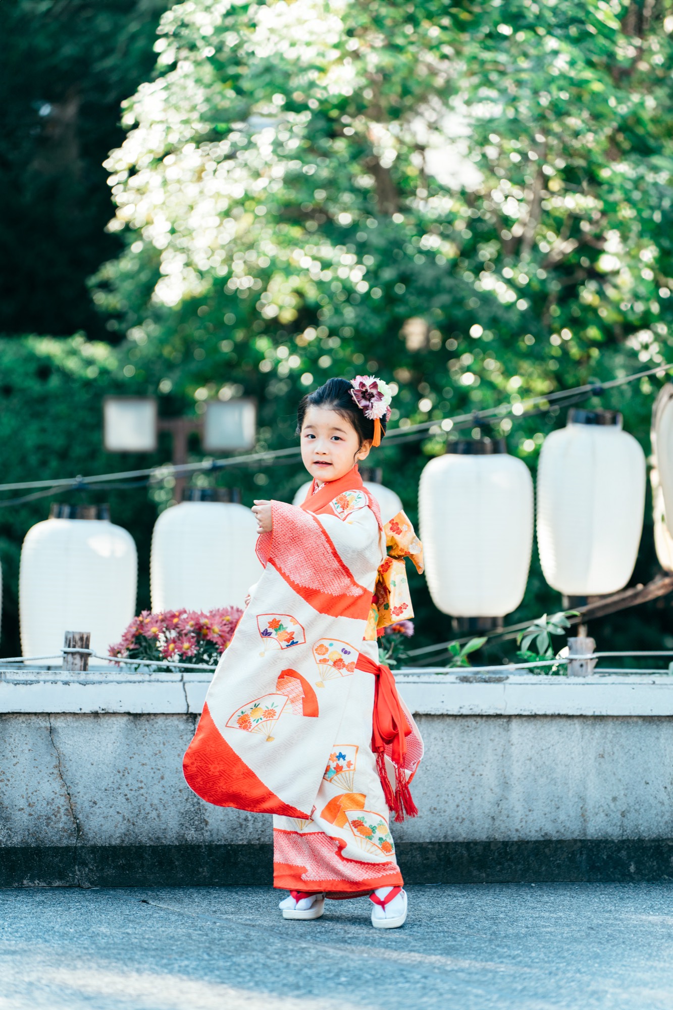 提灯を背景に、お持ち込みの着物で振り返る七五三の7歳の女の子（伊勢山皇大神宮）