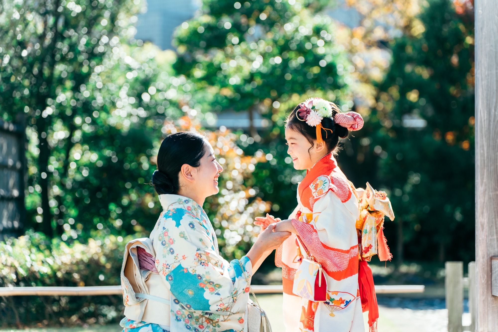 着物姿のお母様としゃがんで笑い合う、七五三の7歳の女の子