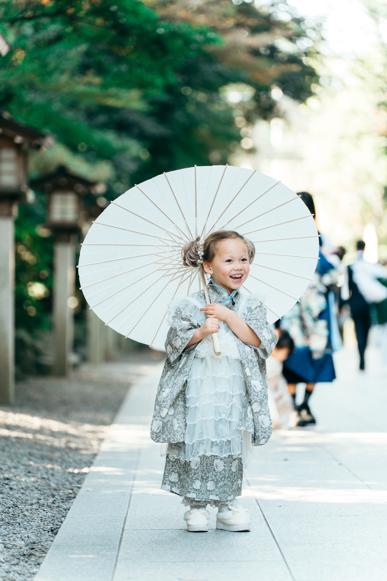 寒川神社の参道で白い和傘を持って笑う、七五三・3歳の女の子