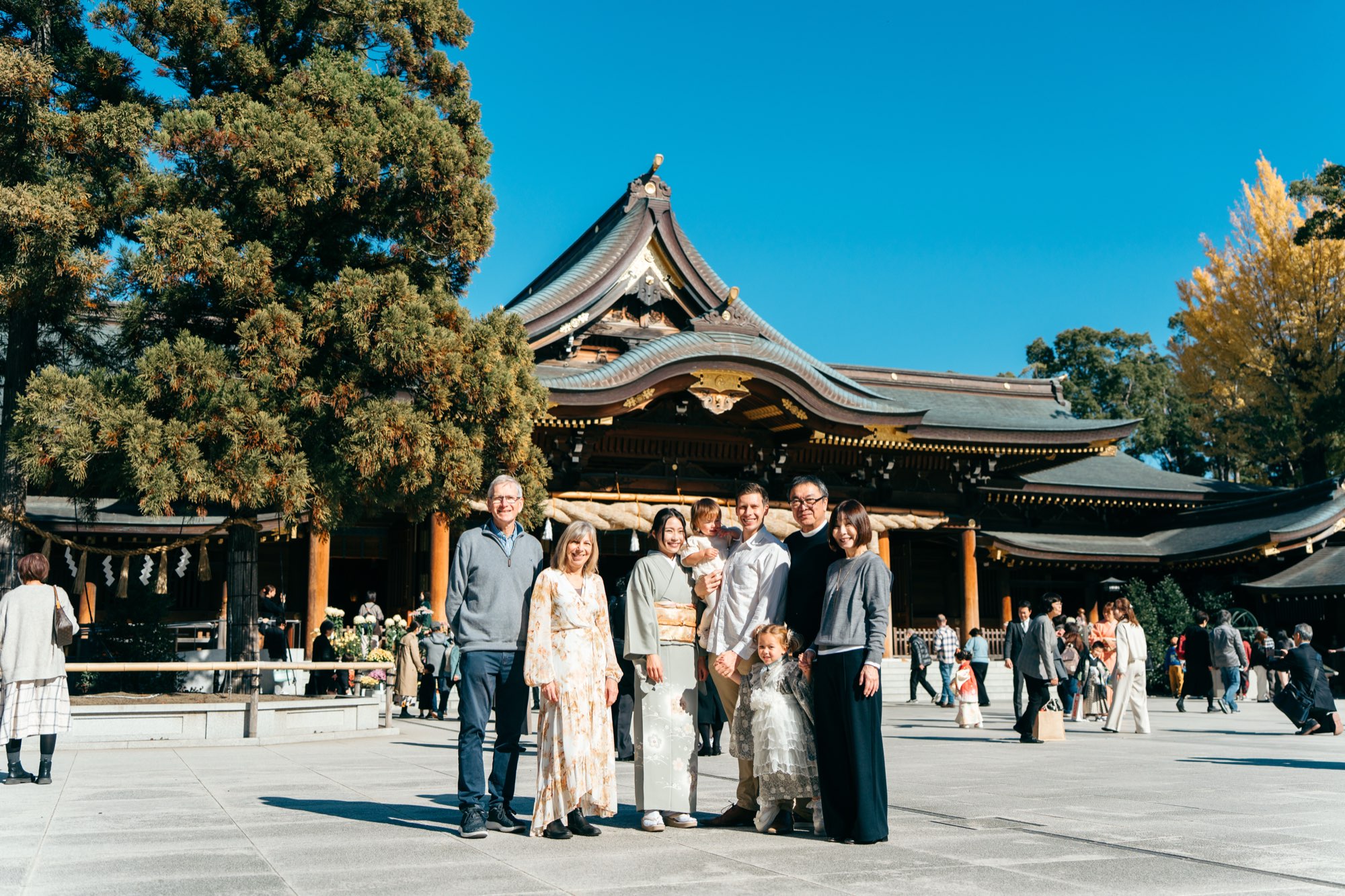 青空の寒川神社・社殿を背景にした三世代の七五三家族写真