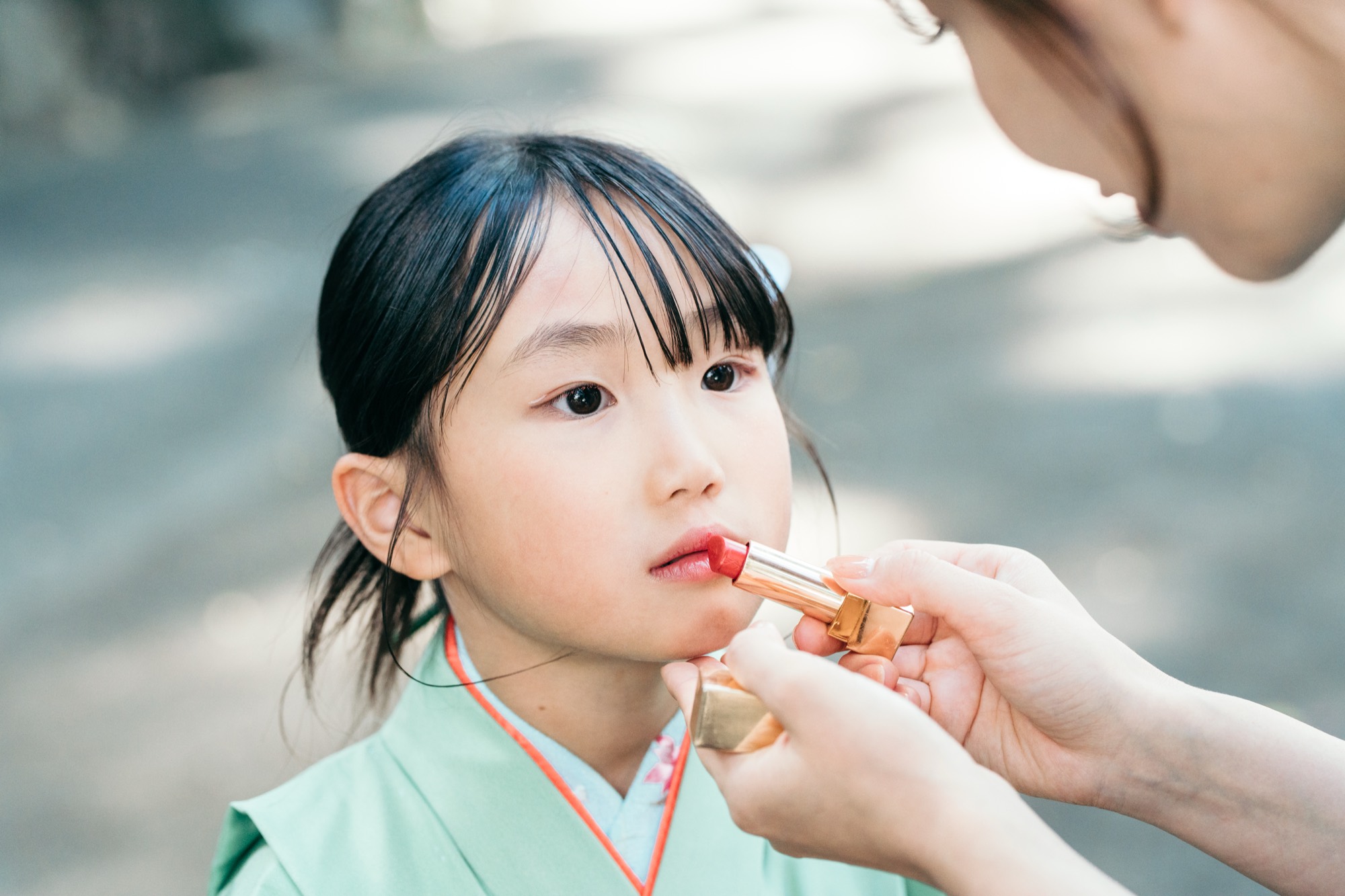 出張のお支度で、7歳の女の子に口紅を塗る七五三のヘアメイクの様子