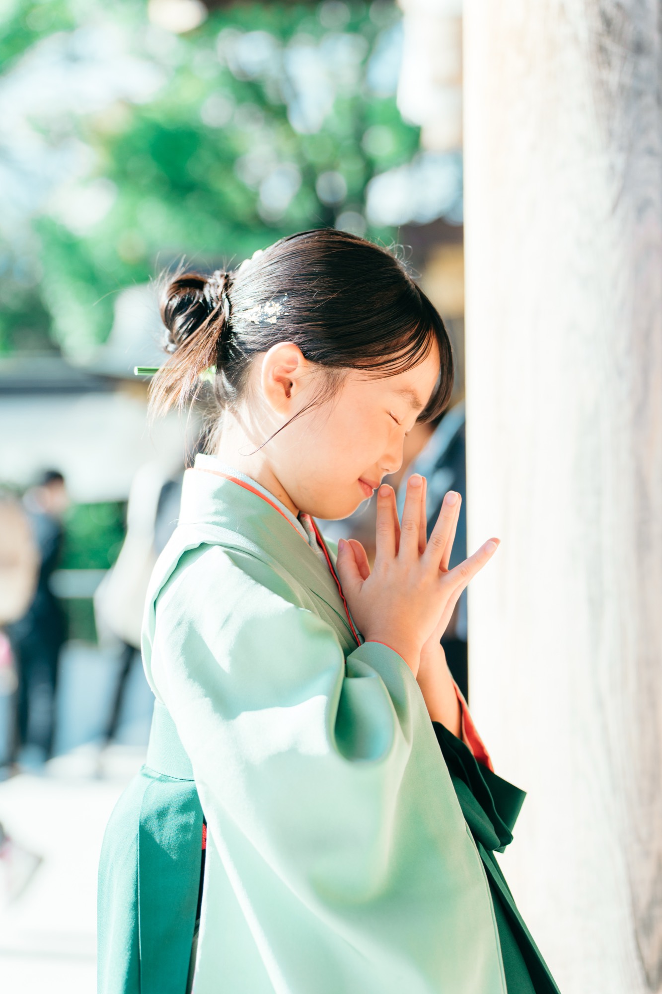 寒川神社でそっと手を合わせてお参りする、袴姿の7歳の女の子