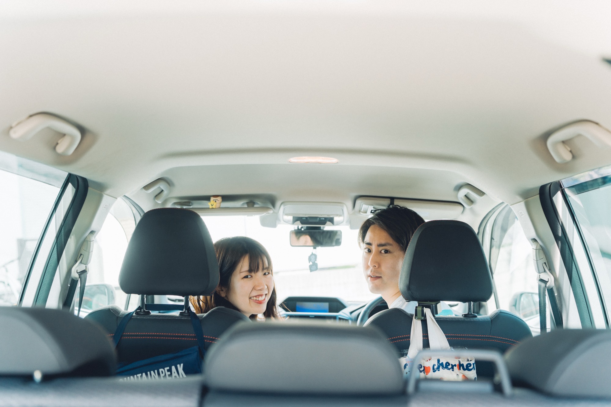 車内で振り返って笑い合うご夫婦。湘南での出張撮影の自然なひとこま