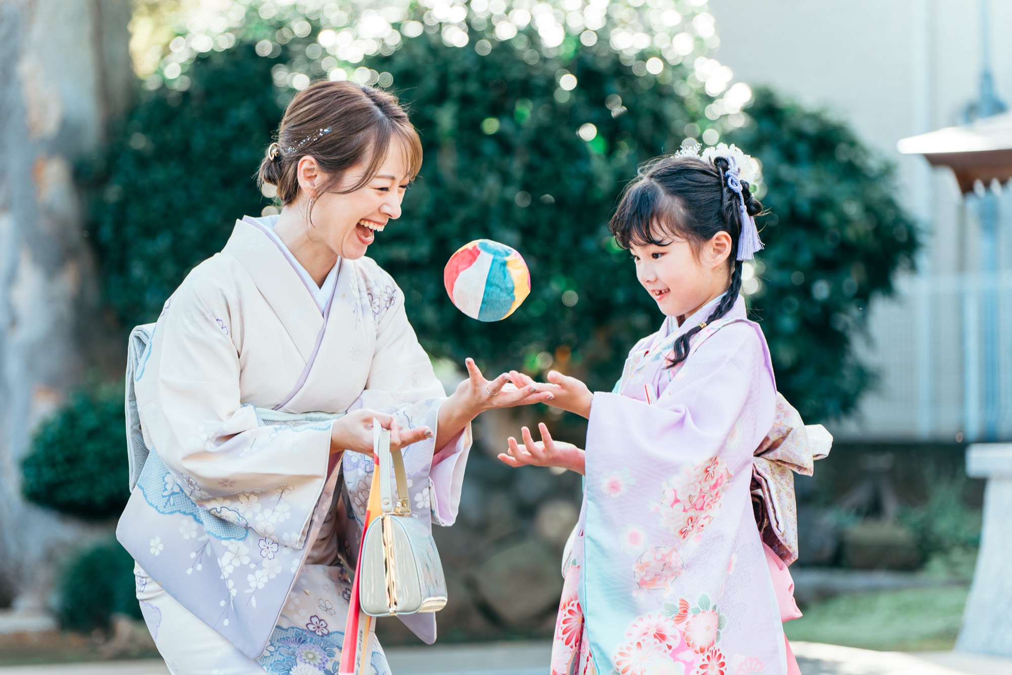 着物姿のお母様と紙風船で遊んで笑い合う、七五三・7歳の女の子（徳丸北野神社）